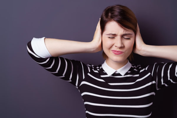 Per mantenere un udito sano, i consigli degli esperti suggeriscono soprattutto uno stile di vita sano, lontani da rumori forti ed esposizioni dannose per il proprio condotto uditivo. In questa foto, una donna che si tappa le orecchie, di fronte a un'eccessiva esposizione di rumore.